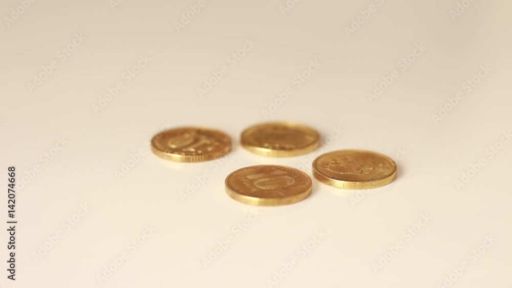 Golden coins dropping on a table Golden coins dropping on a table