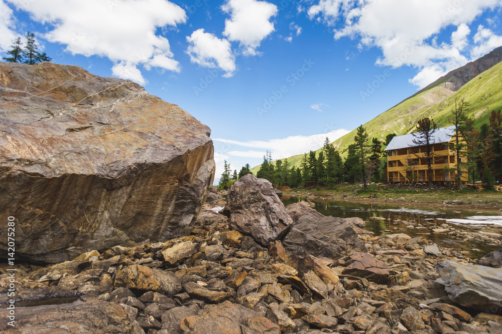 wooden hotel in the mountains near a large rock wooden hotel in the mountains near a large rock