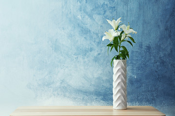 Beautiful white lilies in vase on table