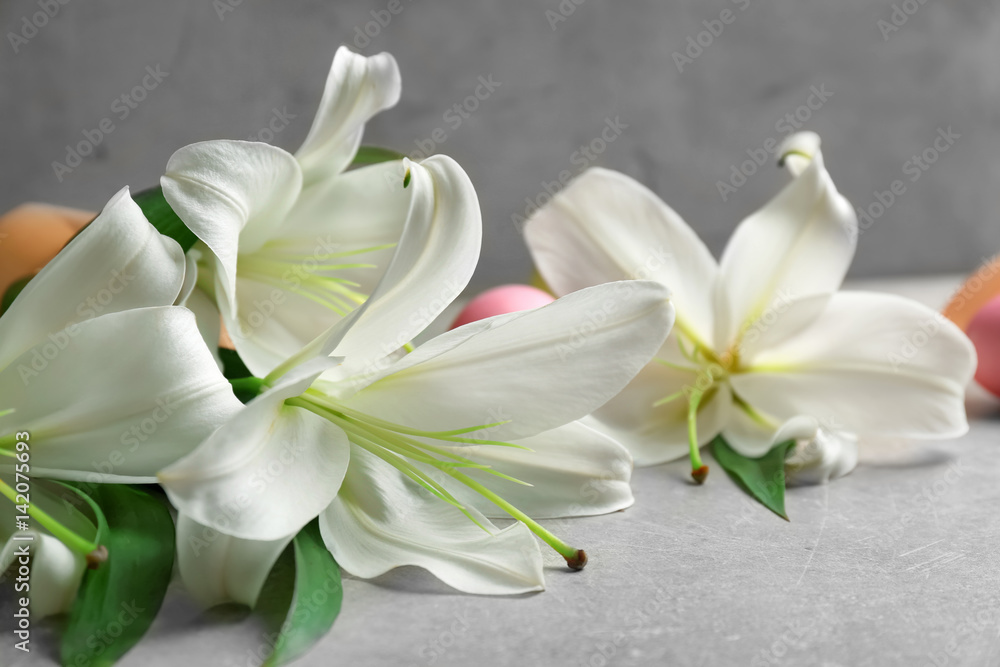 Beautiful lilies and eggs on gray table