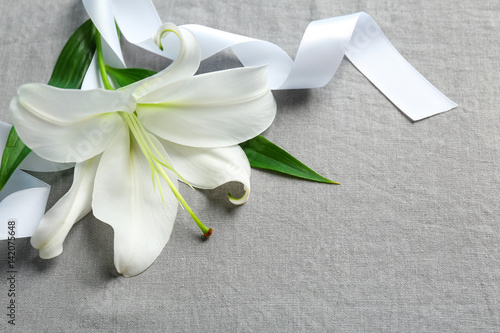 Fototapeta Naklejka Na Ścianę i Meble -  Beautiful lily and ribbon on fabric background