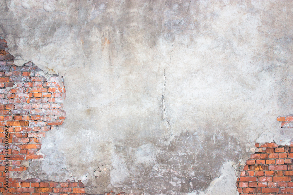 Naklejka premium brick wall with damaged plaster, background shattered cement surface
