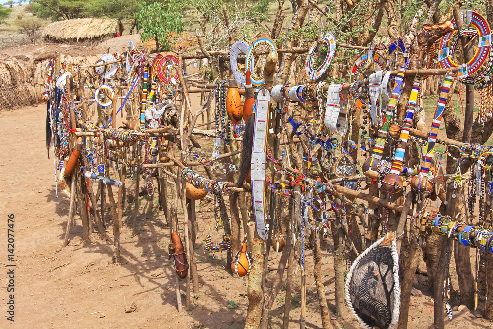 Central part of Maasai village with handmade traditional souvenirs hanging on paling. Serengeti National Park, Tanzania, Africa. 
