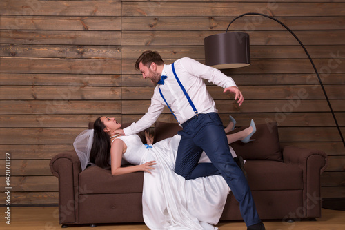 Foto Groom trying to choke bride in white dress