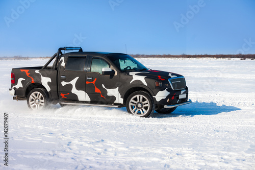 Black truck moving fast on snow