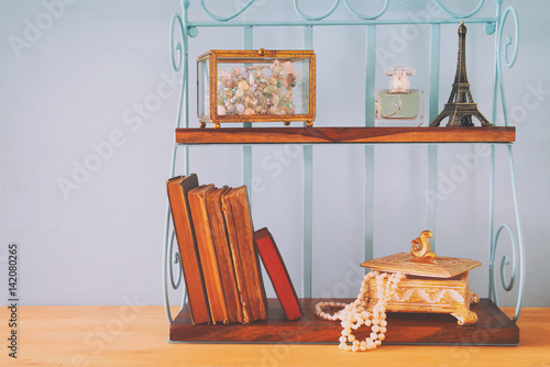 Classic shelf with vintage objects on wooden table.