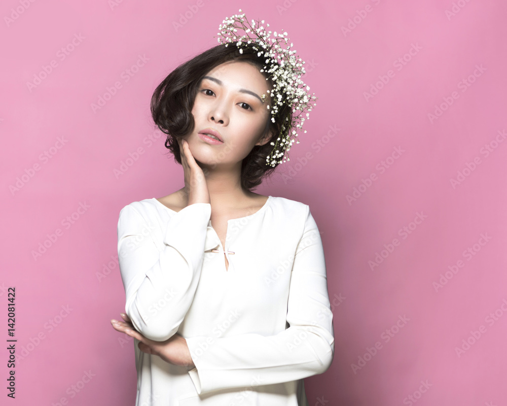 Portrait of asian woman with flowers front of pink background Portrait of asian woman with flowers front of pink background
