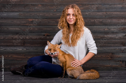 A young beautiful girl holding a wild fox animal that was traumatized by a man and rescued by her and now lives as before