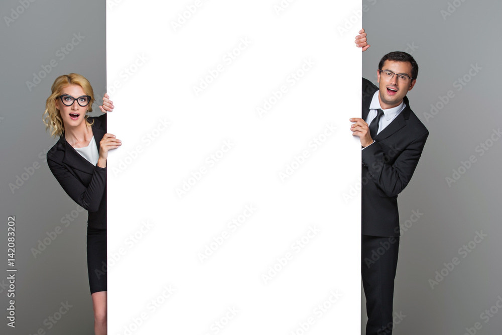 Businessman and business woman with big empty poster Businessman and business woman with big empty poster