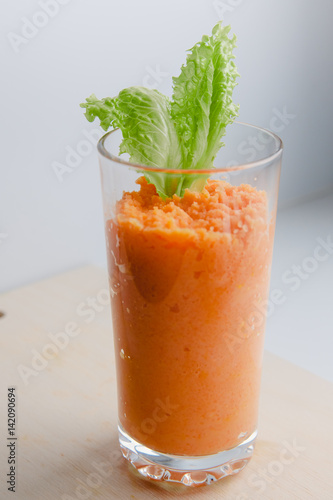 Puree of carrots fresh juice in a glass with salad