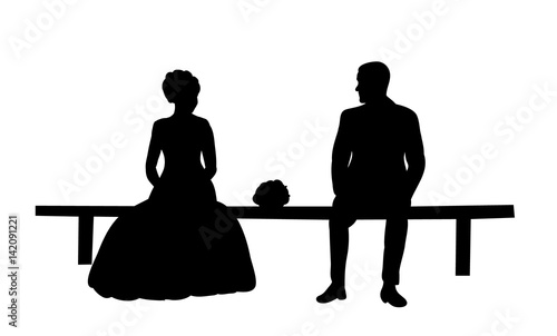 Silhouette of a bridal couple, the bride and groom sitting on a bench