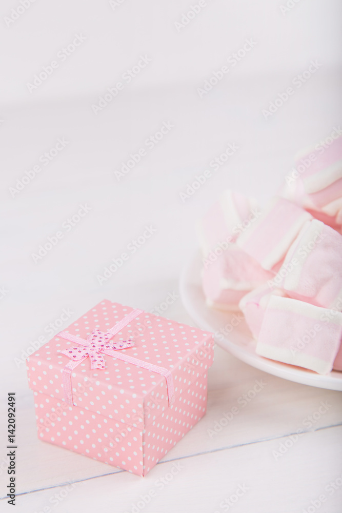 Soft pink and white marshmallow with gift box on white background. Pastel sweets. Soft pink and white marshmallow with gift box on white background. Pastel sweets.