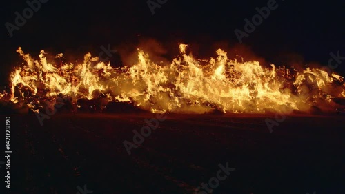Fire storm, horrific fire destroys gigantic hay bales construction, Red Epic slow motion clip