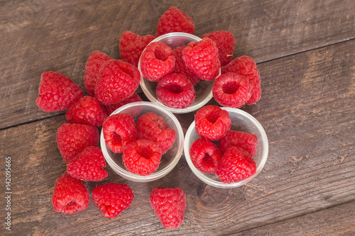 raspberries on the wooden background.