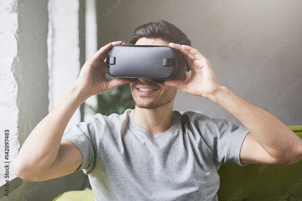 Man Sitting On Sofa At Home Wearing Virtual Reality Headset Man Sitting On Sofa At Home Wearing Virtual Reality Headset
