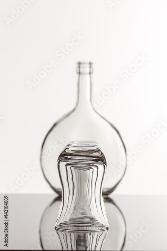 Empty transparent bottle and glass