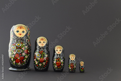 Murais de parede Beautiful black matryoshka dolls with white, green and red painting in front of