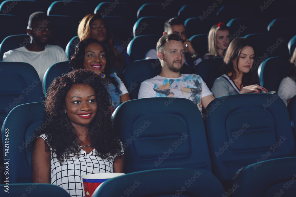 Smiling african woman spending free time in cinema. Smiling african woman spending free time in cinema.