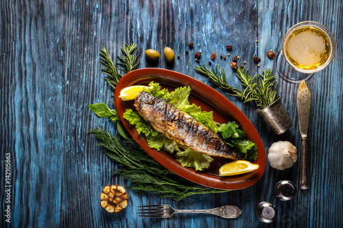 Baked mackerel with lemon on a rustic wooden background