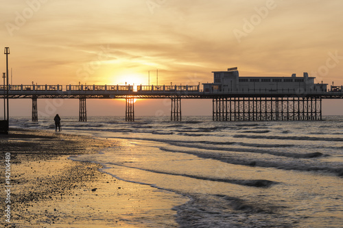 Photographer Shooting the Sun as it Rises Behind Worthing Pier
