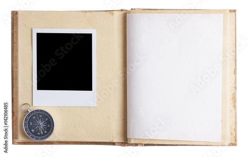 Open empty photo album with instant photo and compass