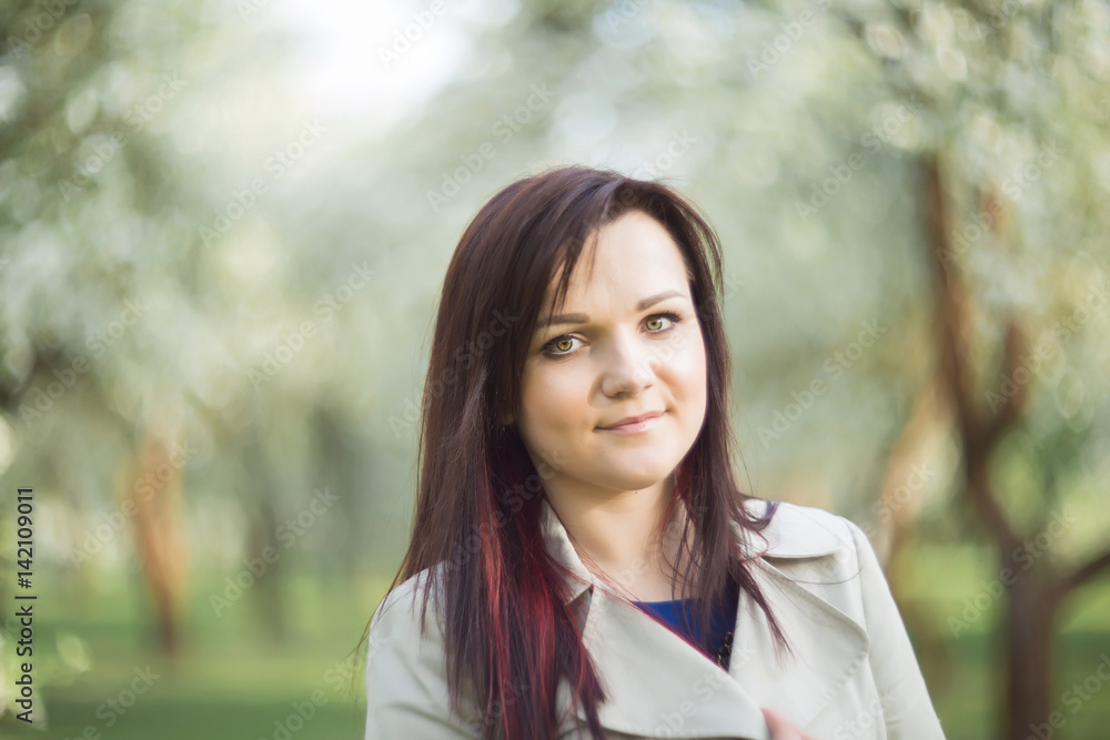 beautiful young brunette woman standing near the blossoming apple tree on a warm spring day beautiful young brunette woman standing near the blossoming apple tree on a warm spring day