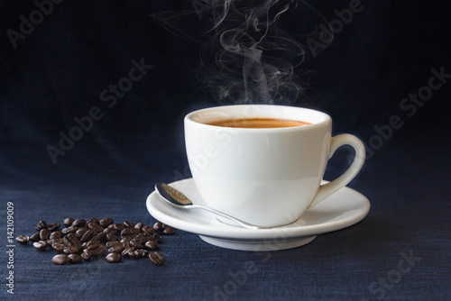 Coffee cup and beans on a dark background