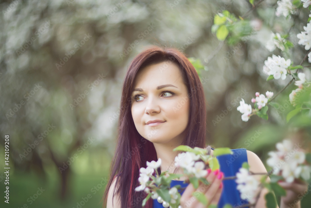 beautiful young brunette woman standing near the blossoming apple tree on a warm spring day beautiful young brunette woman standing near the blossoming apple tree on a warm spring day