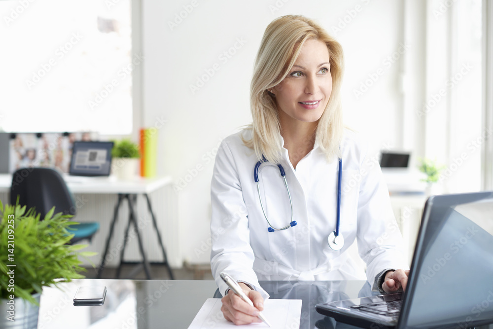 Shot of a female doctor working on medical expertise while sitting at desk in front of laptop. Shot of a female doctor working on medical expertise while sitting at desk in front of laptop.
