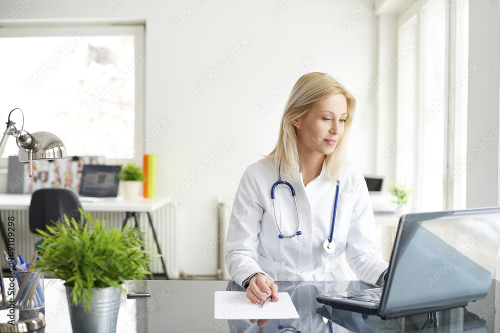 Shot of a female doctor working on medical expertise while sitting at desk in front of laptop. Shot of a female doctor working on medical expertise while sitting at desk in front of laptop.