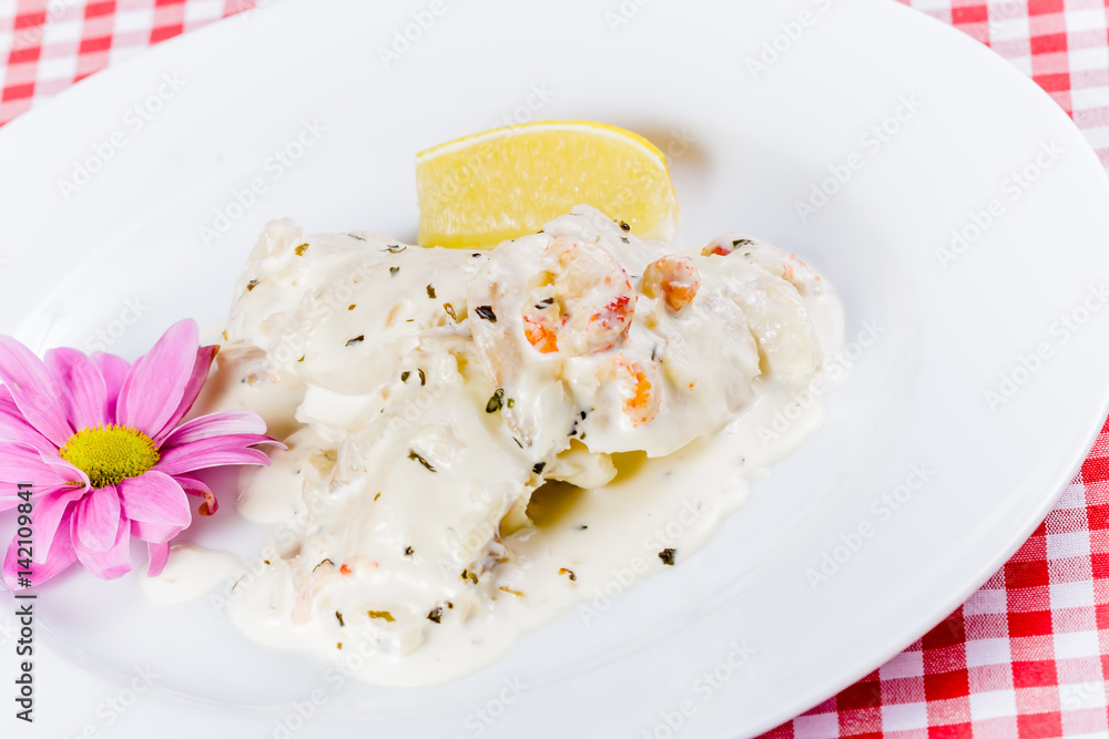 Pike Perch with cream sauce and shrimp on white plate