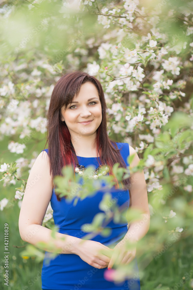 beautiful young brunette woman standing near the blossoming apple tree on a warm spring day beautiful young brunette woman standing near the blossoming apple tree on a warm spring day