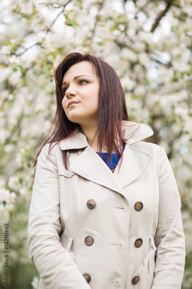 beautiful young brunette woman standing near the blossoming apple tree on a warm spring day beautiful young brunette woman standing near the blossoming apple tree on a warm spring day
