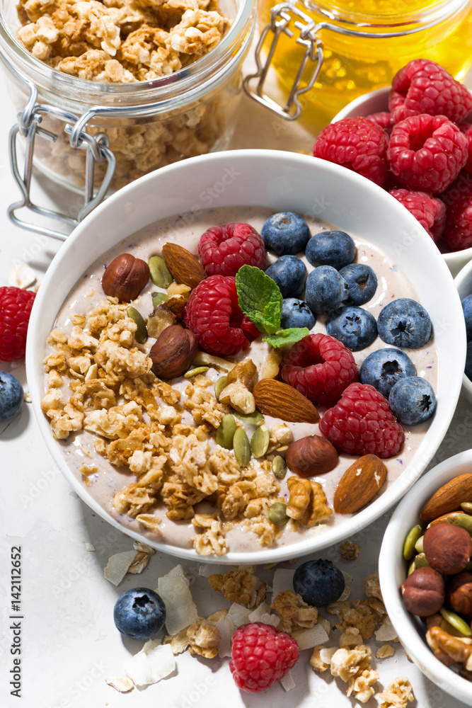 homemade muesli with yogurt and berries for breakfast, vertical closeup homemade muesli with yogurt and berries for breakfast, vertical closeup