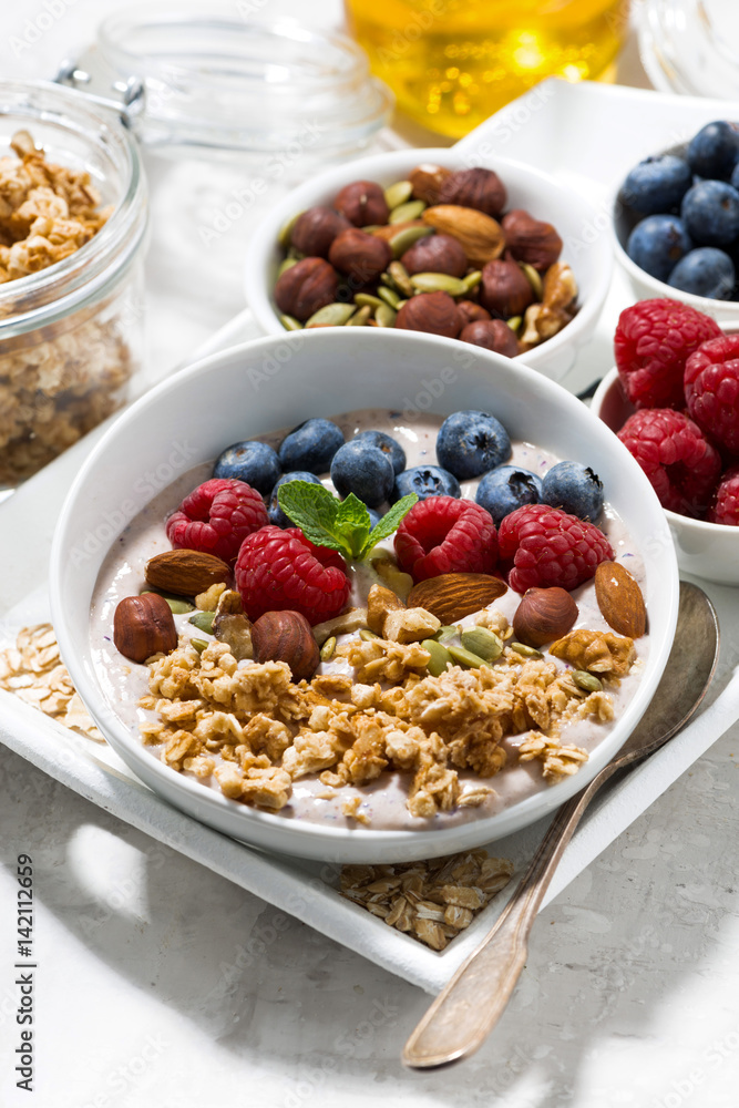 homemade muesli with yogurt and berries for breakfast, vertical homemade muesli with yogurt and berries for breakfast, vertical