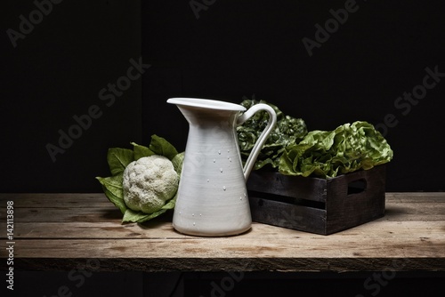 still life with various kinds of vegetables with pictorial light on rustic wooden tables