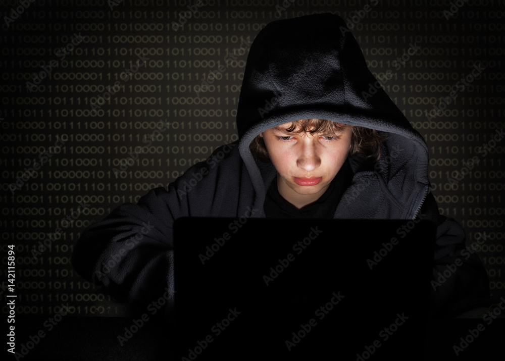 Teenager hacker at the computer on a digital background Teenager hacker at the computer on a digital background
