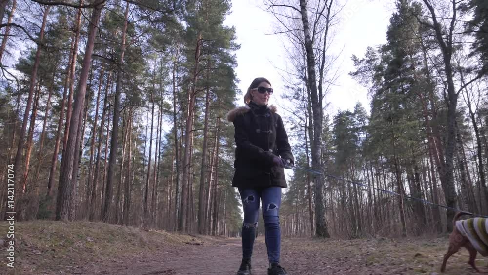 Woman playing with her dog and walking towards camera. Woman playing with her dog and walking towards camera.