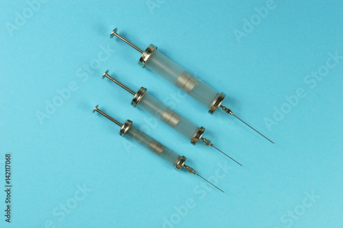 old injecting syringe on blue background