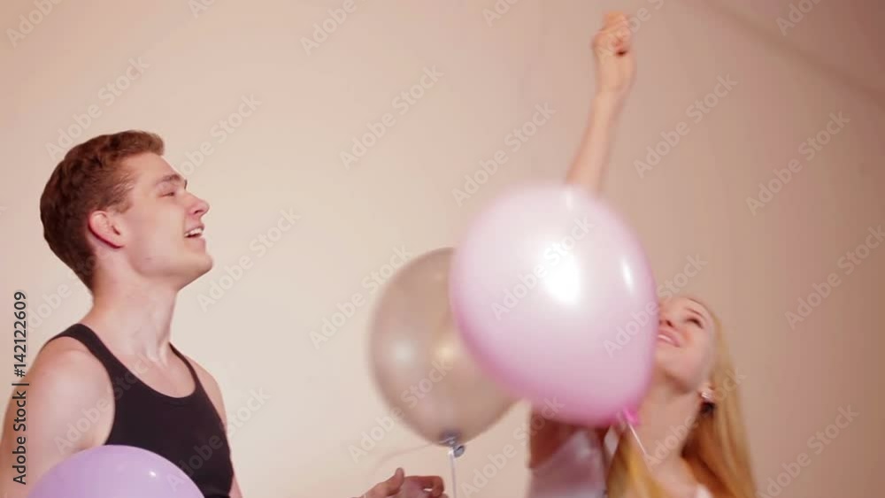 Young couple fooling like children with balloons Young couple fooling like children with balloons
