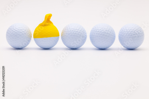 White golf balls with funny cap on the white background.