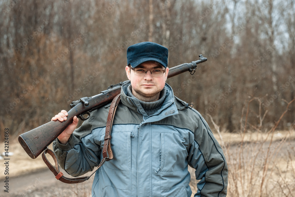 Fototapeta premium Young handsome man with a gun