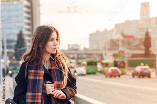 Young attractive girl in the city at sunset
