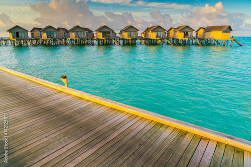 Fototapeta Naklejka Na Ścianę i Meble -  Beautiful water villas in tropical Maldives island at the sunrise time .