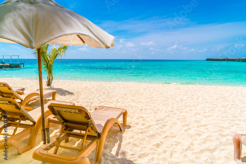 Fototapeta Naklejka Na Ścianę i Meble -  Beach chairs with umbrella at Maldives island, white sandy beach and sea .