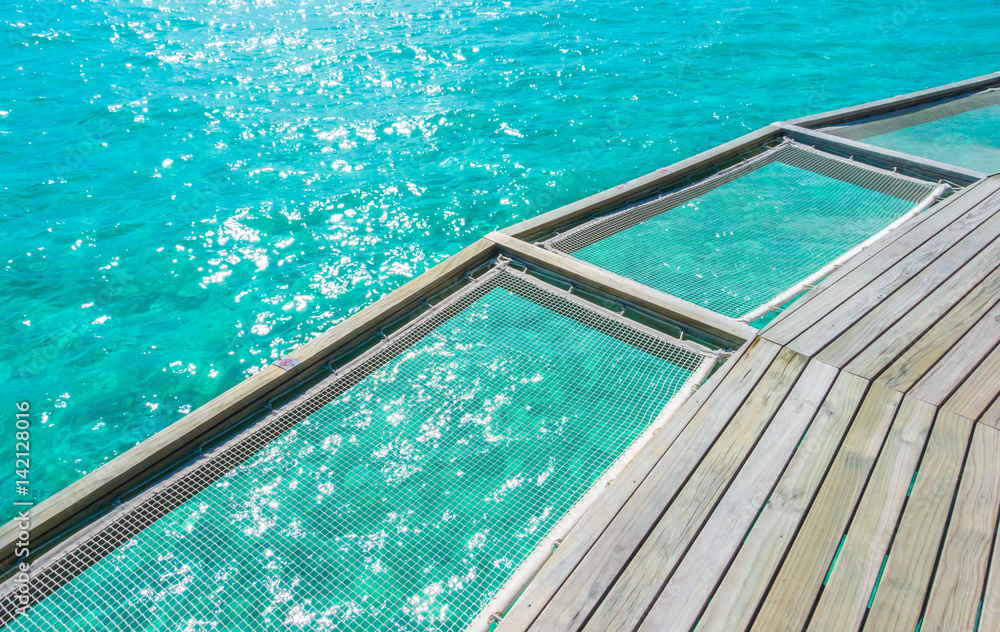 Obraz premium Vacation net seat in tropical Maldives island and beauty of the sea with the coral reefs .