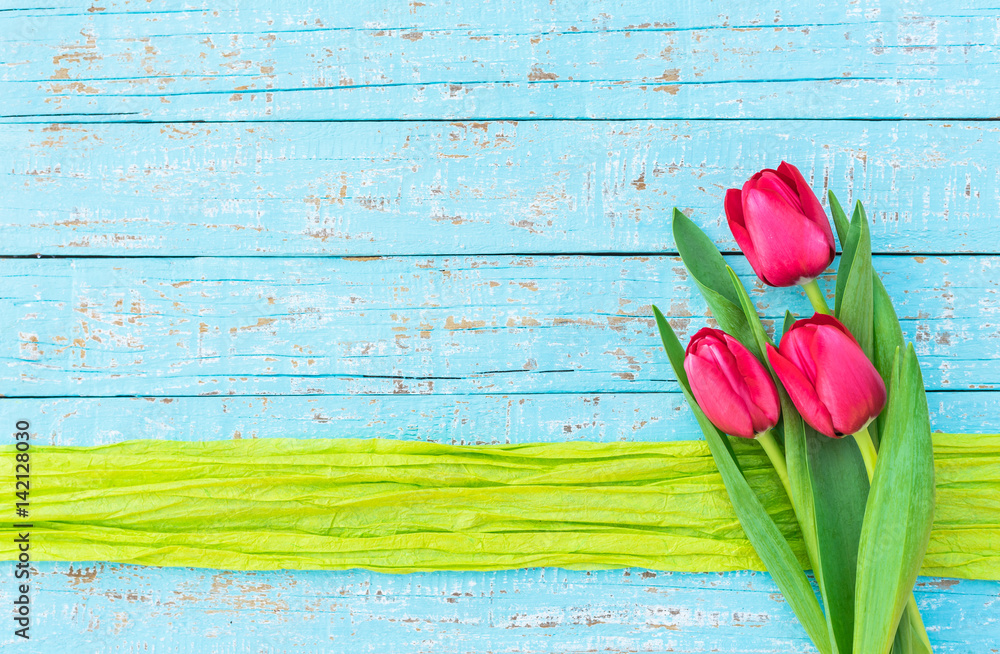 Frühling Blumen Strauss Tulpen pink auf Holz Hintergrund blau mit Geschenkband grün