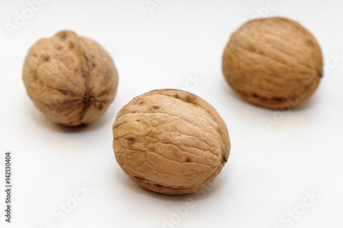 Three walnuts on a white background