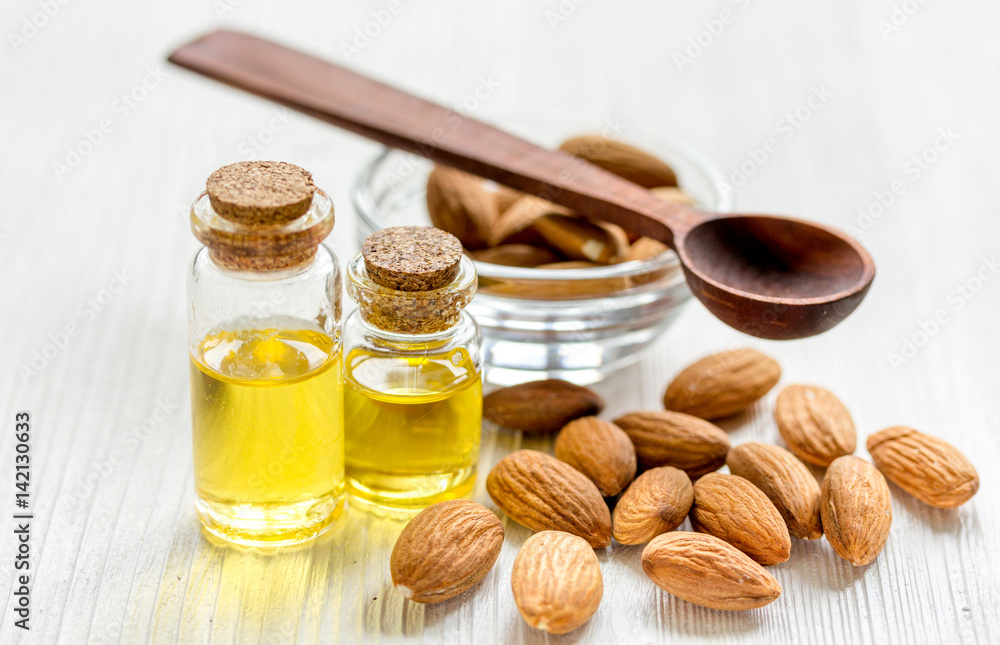 cosmetic and therapeutic almond oil on light wooden background cosmetic and therapeutic almond oil on light wooden background