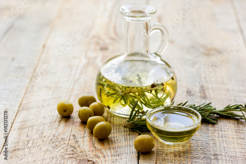 jar with oil with olives on wooden table background mock up